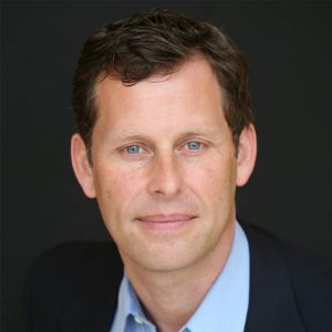 Mike Maples in front of a black backdrop.