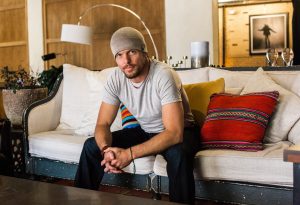 Tim Ferriss on a white couch with a distressed blue frame.