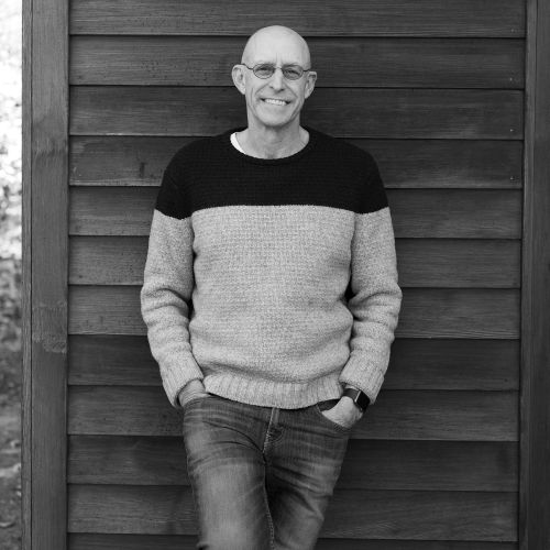 Michael Pollan standing against a clapboard wall outside.