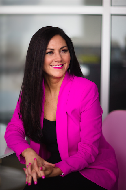 Cindy Eckert in an office building wearing a signature pink blazer.