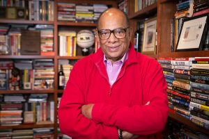 Coach George Raveling in his home office surrounded by all of his books and many keepsakes and awards.