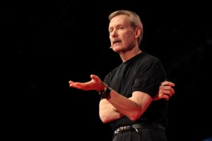 Gary Keller in a black t-shirt and black slacks, speaking onstage.