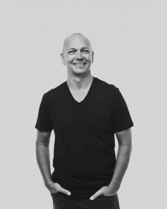Tony Fadell in a dark V-neck t-shirt, smiling.
