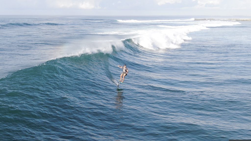 Josh Waitzkin foil surfs a wave.