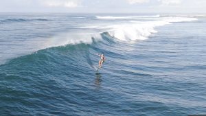 Josh Waitzkin foil surfs a wave.