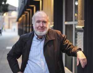 Kevin Kelly standing outdoors next to a long building.
