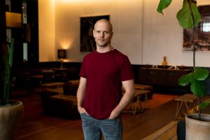 Tim Ferriss in jeans and a t-shirt in a large lobby.