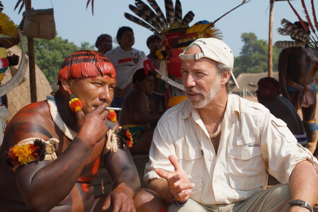 Dr. Mark Plotkin sitting outdoors, talking with a shaman.