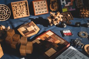 Many puzzles made of different colored woods, all on a dark blue cloth.